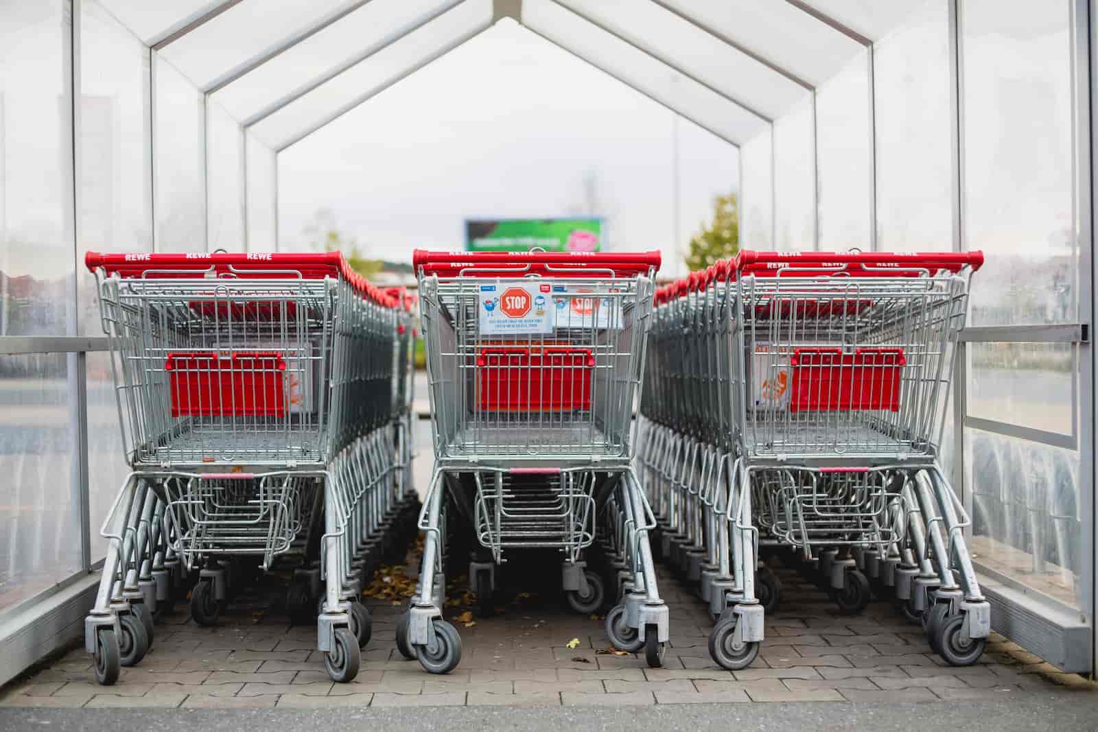 Lege boodschappen karren rood onder een afdak